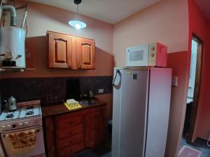 a kitchen with a refrigerator and a microwave on top of it at Monoambiente San Bernardo in San Bernardo +5 photos