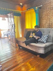 um homem sentado num sofá a jogar um jogo de vídeo em Villa zann kaktus em Nempel