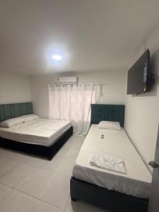 a room with two beds and a tv in it at Apartamento moderno central in Estación El Salto