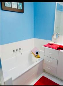 a bathroom with a tub and a sink and a mirror at Charming Townhouse Kirra Beach in Tweed Heads +15 photos