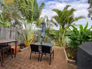 a patio with a table and chairs and an umbrella at Charming Townhouse Kirra Beach in Tweed Heads