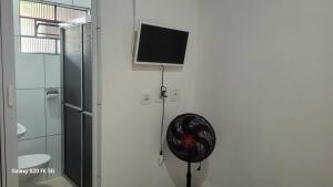 een flatscreen-tv aan de muur van een badkamer bij Hostel Pé na praia - Quartos e Barracas Camping in Caraguatatuba +10 foto's