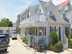Ocean Side Home In Brant Beach 36525 في Brant Beach: البيت الأبيض مع العلم الأمريكي أمامه