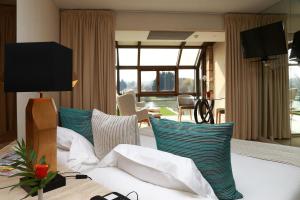 um quarto de hotel com uma cama com almofadas azuis e brancas em La Côte Saint Jacques em Joigny