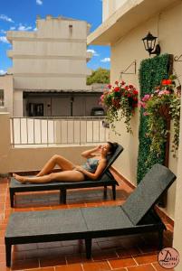 een vrouw op een stoel op een balkon bij Hotel Demi in Villa Gesell +19 foto's