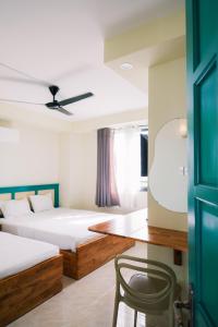 Un dormitorio con dos camas y una silla dentro. en De Rivé Homestay 3 - Bến Ninh Kiều, en Can Tho