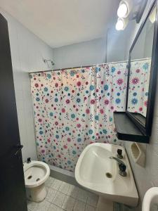 Un baño con cortina de ducha con inodoro y lavabo. en NEW Hotel Playa, en Santa Teresita 38 fotos más
