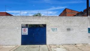 een gebouw met een blauwe deur en een bordje 'verboden te parkeren' bij Hostel Pé na praia - Quartos e Barracas Camping in Caraguatatuba