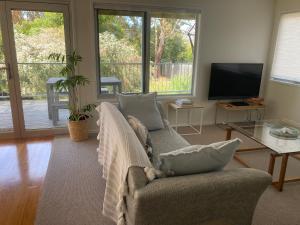 a living room with a couch and a television at 20 Bradley in Coles Bay