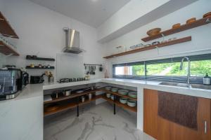 a kitchen with white counters and a sink and a window at Gandum Villa Complex - Luxury Boutique Stay Uluwatu in Uluwatu