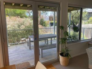 a screened in porch with a bench on the deck at 20 Bradley in Coles Bay