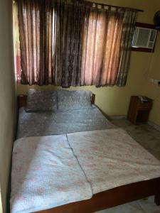 Un dormitorio con una cama grande con ventana. en Aso Rock Hotel Bar and Restaurant, en Loburo