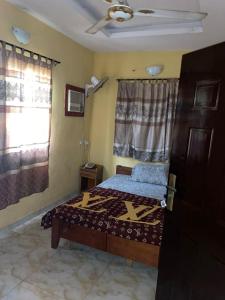 Un dormitorio con una cama y una ventana en Aso Rock Hotel Bar and Restaurant, en Loburo