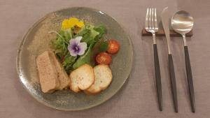 Un plato de comida con pan y una ensalada con flores. en Haiji, en Shizukuishi