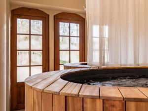 a hot tub in a room with two windows at Abbaye Des Vaux De Cernay in Cernay-la-Ville