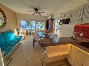 a kitchen and living room with a blue couch at Luxury Beachfront Condo at Iguana-Ixtapa in Ixtapa