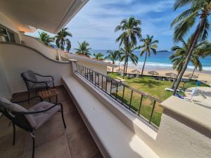 a balcony with chairs and a view of the beach at Luxury Beachfront Condo at Iguana-Ixtapa in Ixtapa
