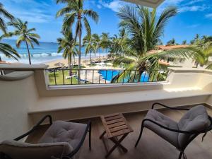 a balcony with chairs and a view of the beach at Luxury Beachfront Condo at Iguana-Ixtapa in Ixtapa
