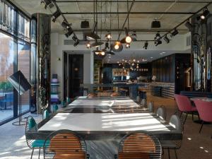 a large table in a room with chairs and a bar at Tribe Perth Kings Park in Perth