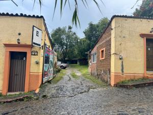 Un callejón con dos edificios y un coche en una calle. en Cabañita TEPOZTLÁN, en Tepoztlán