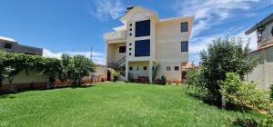 een huis met een gazon ervoor bij Chalet Tunari in Quillacollo