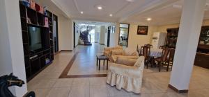 een woonkamer met stoelen en een televisie en een tafel bij Chalet Tunari in Quillacollo