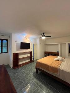 a bedroom with a bed and a flat screen tv at Marvin Suites in Holbox Island