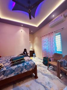 um menino sentado em uma cama em um quarto com bagagem em Hemanth Heritage em Hospet mais 34 fotografias