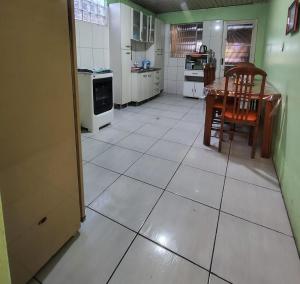 a kitchen with a large white tiled floor at Casa familiar ampla in São Gabriel +9 photos