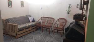 a living room with two chairs and a couch at Casa familiar ampla in São Gabriel
