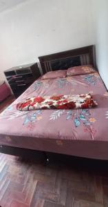 a bed with a purple bedspread with flowers on it at Casa familiar ampla in São Gabriel