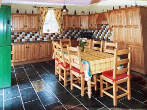 エニスにあるPrivate house in scenic location sleeping 8 peopleのキッチン(木製テーブル、椅子、キャビネット付)