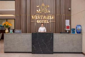 a woman standing behind a counter in a hotel at Cat Ba Wistaria Hotel- Jacuzzi Rooftop & Fitness in Cat Ba +71 photos