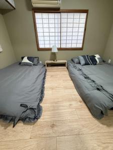 twee eenpersoonsbedden in een kamer met een raam bij star in Osaka