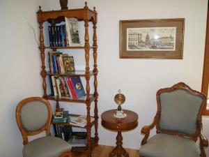 een kamer met 2 stoelen en een boekenplank met boeken bij Pension Espenhof in Strüth