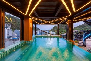 a swimming pool in a building with a slide at Cat Ba Wistaria Hotel- Jacuzzi Rooftop & Fitness in Cat Ba