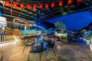 a restaurant with tables and chairs at night at Cat Ba Wistaria Hotel- Jacuzzi Rooftop & Fitness in Cat Ba