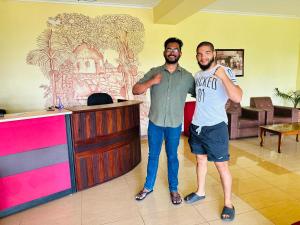 Dos hombres de pie junto a un mostrador en una habitación. en Nature Walk Resort, en Kandy