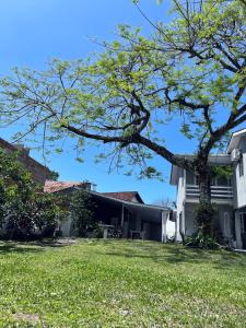 ein Haus mit einem Baum im Hof in der Unterkunft Casa inteira em Pontal do Sul in Pontal do Paraná