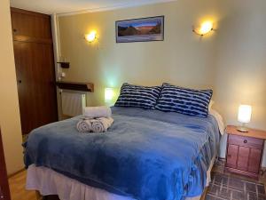 a bedroom with a blue bed with towels on it at Hostal Solor in San Pedro de Atacama