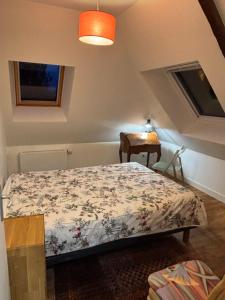 een slaapkamer met een bed in de hoek van een kamer bij Le premier etage indépendant dans une maison avec grand parc in Lorient +8 foto's