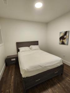 Lakeview Breaktrail Stays في Crosby Island: غرفة نوم مع سرير مع شراشف بيضاء وجلستين نوم