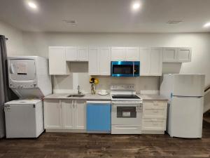 a kitchen with white cabinets and a sink and a microwave at Lakeview Breaktrail Stays in Bedford