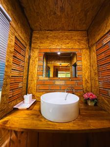 a large white bath tub in a wooden bathroom at Mook Tamarind Resort in Koh Mook