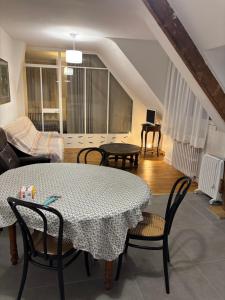een woonkamer met een tafel, stoelen en een bank bij Le premier etage indépendant dans une maison avec grand parc in Lorient