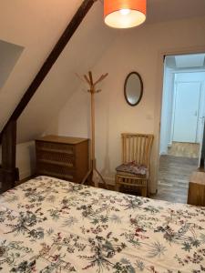 een slaapkamer met een bed, een ladekast en een spiegel bij Le premier etage indépendant dans une maison avec grand parc in Lorient