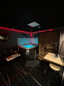 a room with a bar with a table and a counter at Ô Saphir Spa - Maison N1 in Denain