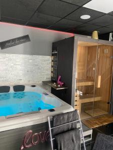 a jacuzzi tub in a room with at Ô Saphir Spa - Maison N1 in Denain