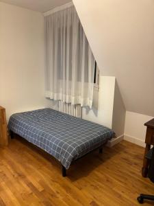 een bed in een kamer met een raam bij Le premier etage indépendant dans une maison avec grand parc in Lorient