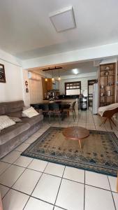 ein Wohnzimmer mit Sofa und Tisch in der Unterkunft Casa de Praia - 4 quartos Centro in Bombinhas